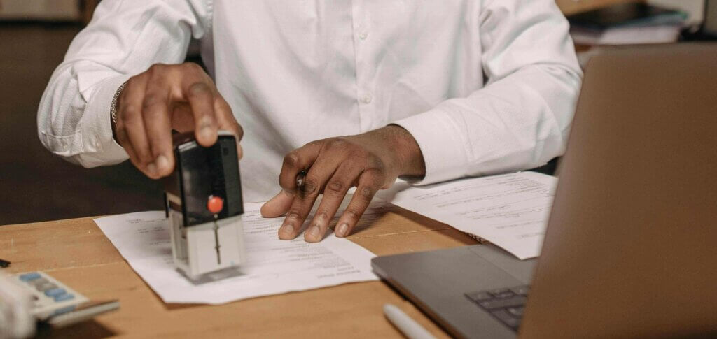 Man stamping paper with black stamp.