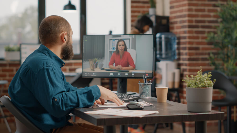 A man and a woman are on a conference call A man and a woman are on a conference call